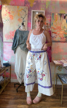 Load image into Gallery viewer, Model wearing white vintage tablecloth wide-leg pants with lavender stripes and wildflower bouquets, front view