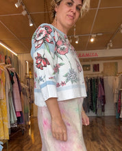 Load image into Gallery viewer, Side view of a relaxed shirt made from a vintage printed tablecloth with pink floral motifs and a pale blue border